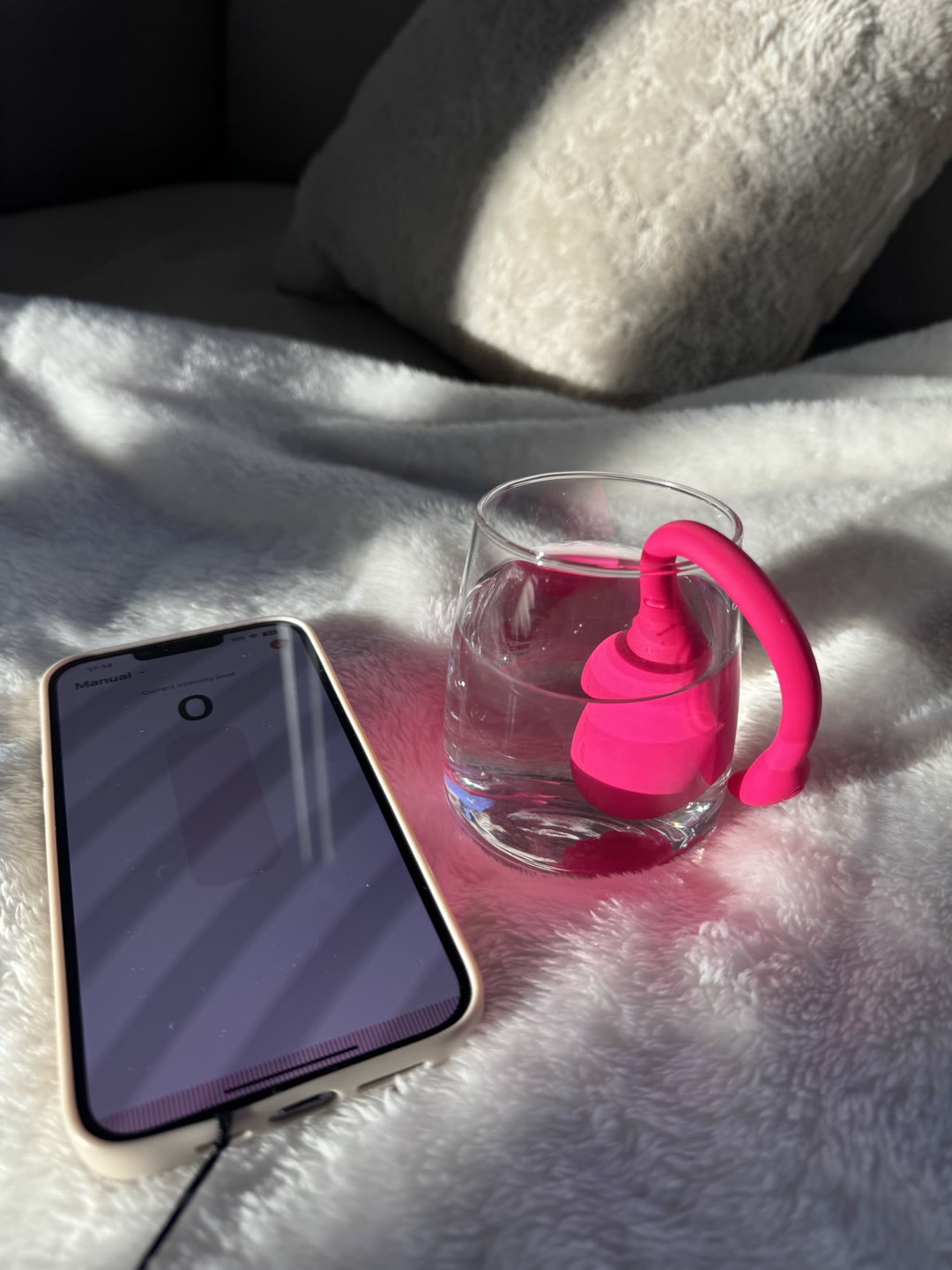 The Flamingo fully submerged in a glass of water beside the app, still running